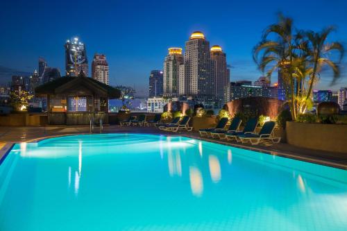 a swimming pool with a city skyline in the background at Ramada by Wyndham D MA Bangkok in Bangkok