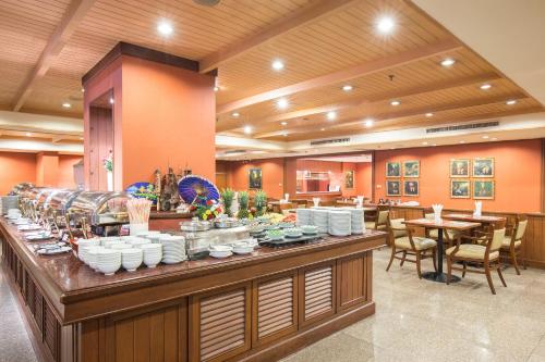 a buffet line in a restaurant with tables and chairs at Ramada by Wyndham D MA Bangkok in Bangkok