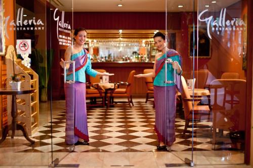 two women standing in front of a store window at Ramada by Wyndham D MA Bangkok in Bangkok