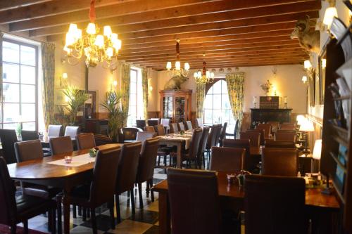 a dining room with tables and chairs and chandeliers at Vakantie Logies de Kleine Motte in Sint-Truiden