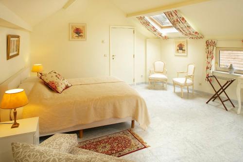 a bedroom with a bed and a table and chairs at Vakantie Logies de Kleine Motte in Sint-Truiden