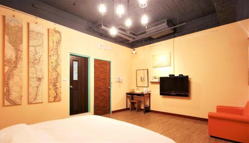 a bedroom with a bed and a tv on the wall at DongNing Atlas Hotel in Tainan