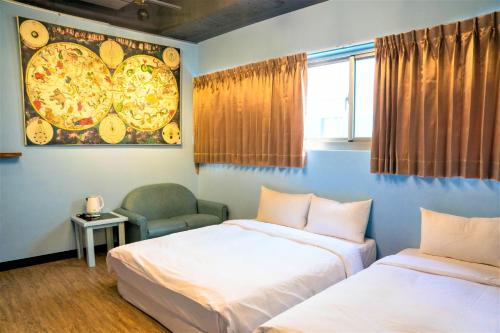 two beds in a room with a pizza painting on the wall at DongNing Atlas Hotel in Tainan