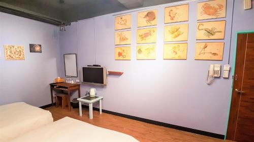 a room with a bed and a tv on a wall at DongNing Atlas Hotel in Tainan