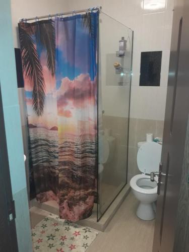 a bathroom with a shower curtain with a palm tree at Aquazure Residence in Mamaia Sat/Năvodari