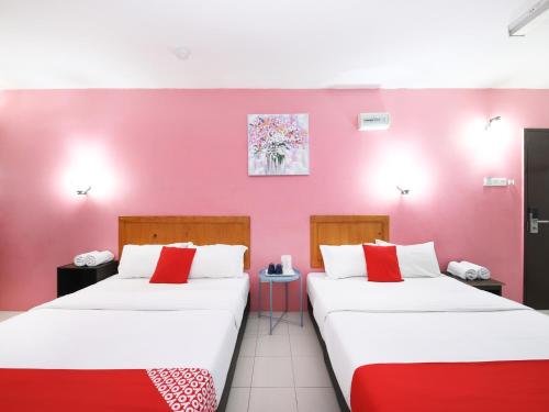 2 letti in una camera con parete rosa di Super OYO 502 Midah Inn Puchong a Puchong