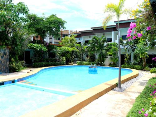 a large swimming pool in front of a building at Baan Sabaaidee - Adult Friendly in Hua Hin