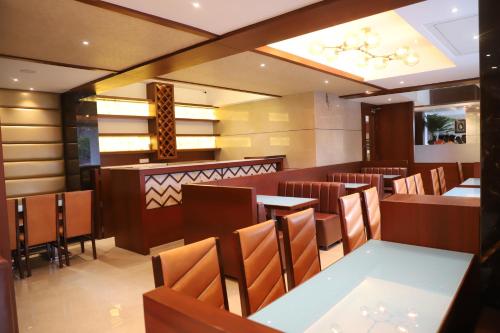 a restaurant with tables and chairs and a chandelier at Shikin Hotels (Close to Palm Beach Road) in Navi Mumbai