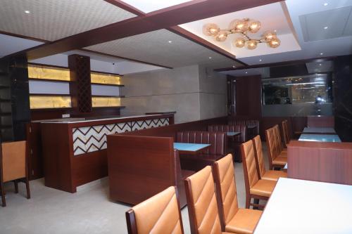 a dining room with tables and chairs and a chandelier at Shikin Hotels (Close to Palm Beach Road) in Navi Mumbai