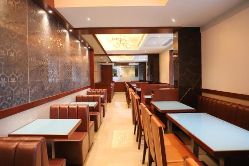 a dining room with tables and chairs in it at Shikin Hotels (Close to Palm Beach Road) in Navi Mumbai