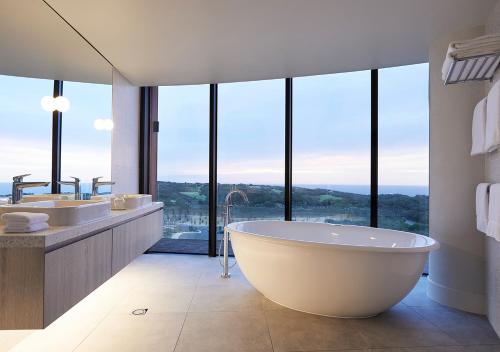 uma grande casa de banho com 2 lavatórios e uma banheira em RACV Cape Schanck Resort em Cape Schanck