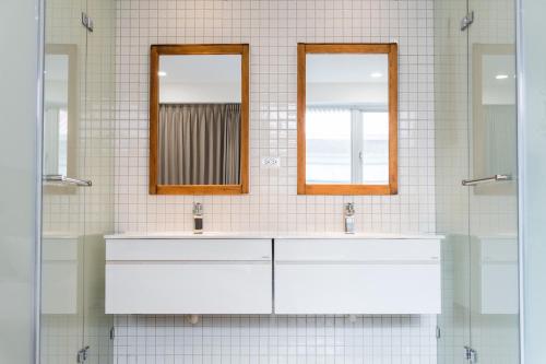 a bathroom with two sinks and two mirrors at Sleep jia in Tainan