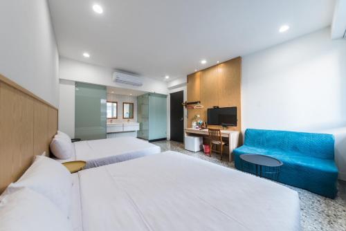 台南的住宿－吃飽睡好歡迎回家，酒店客房,设有两张床和一张蓝色的沙发