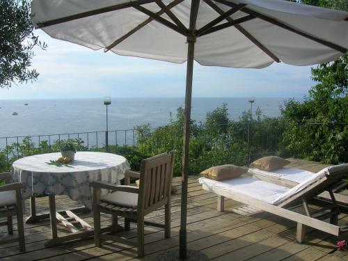 a table and chairs under an umbrella on a deck at Apartments Olive Garden in Piran