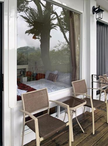 a porch with a bed and two chairs and a table at SunSweet House in Fanlu