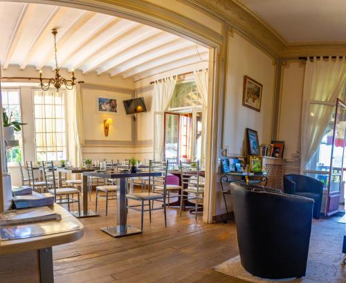 um restaurante com mesas e cadeiras num quarto em Hotel Bellevue em Hendaye