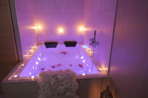 ein lila Zimmer mit einer Badewanne mit Beleuchtung in der Unterkunft LE NID A BULLES in Bischheim