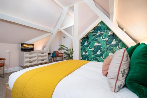a bedroom with a bed with a yellow and green blanket at Coed Mawr Hall Bed & Breakfast in Conwy