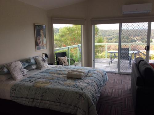 ein Schlafzimmer mit einem großen Bett und einem Balkon in der Unterkunft Forrest River Valley- Blue Wren Studio in Forrest