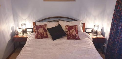 a bedroom with a bed with pillows and two lamps at York's Lookout Lodge Bed And Breakfast in York