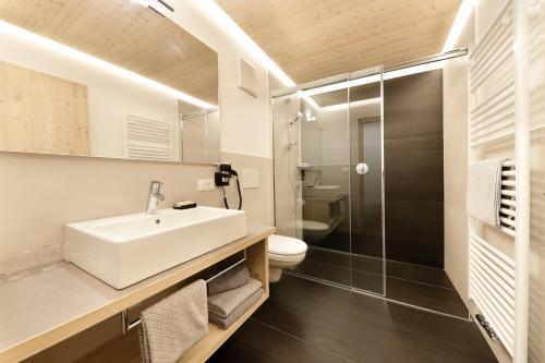 a bathroom with a sink and a toilet and a shower at Residence Apartment Nelkenstein in Schenna