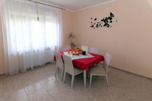 ein Esszimmer mit einem roten Tisch und Stühlen in der Unterkunft Apartman Branka in Ližnjan