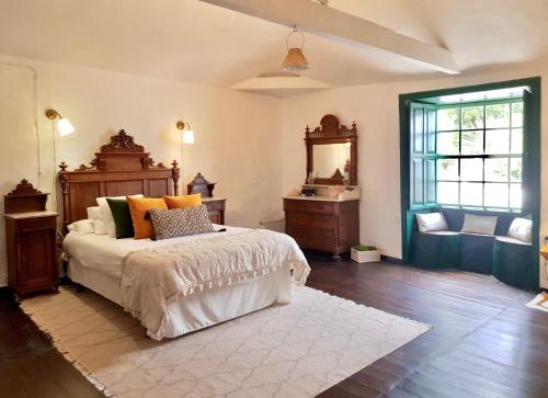 een slaapkamer met een bed, een dressoir en een spiegel bij Emblemática Los Helechos in Los Realejos