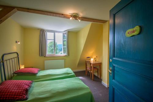 ル・ホーヴァルトにあるVilla Louisental - Gruppenunterkunft für Selbstversorgerのベッドルーム1室(ベッド2台、青いドア付)