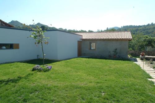 a yard with a blue house and a tree at Casa Rural Vilaboa in Allariz