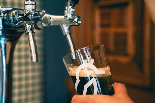 a person holding a glass with a peace sign on it at Mido Hostel in Seogwipo