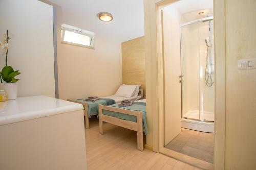 La salle de bains est pourvue d'une douche, d'une chaise et d'un miroir. dans l'établissement Villa Paula with 7 bedrooms, heated 36sqm private pool, Jacuzzi, Gym and sea views, à Kaštela