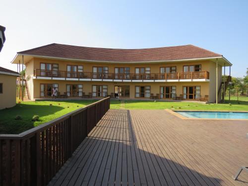 a large building with a pool in front of it at Riverview Inn in Malelane