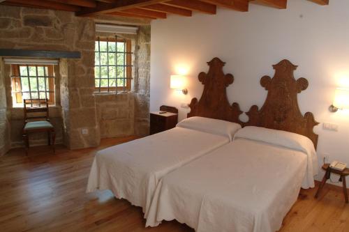 a bedroom with two beds with white sheets at Casa Rural Vilaboa in Allariz