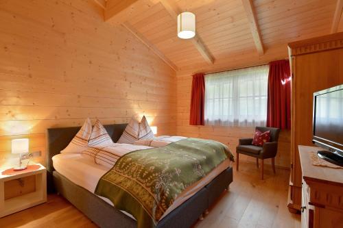 ein Schlafzimmer mit einem Bett in einem Holzzimmer in der Unterkunft Ferienwohnung Lechenhof in Söll