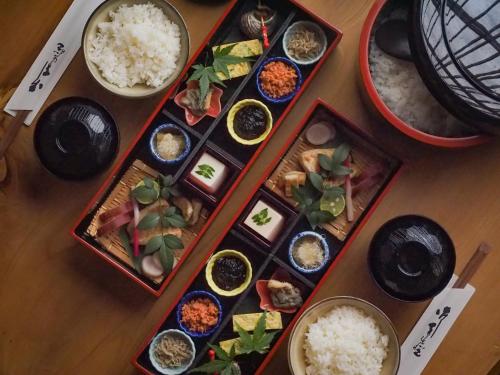 a table with plates of food and bowls of rice at Kyoto Machiya Cottage Karigane in Kyoto