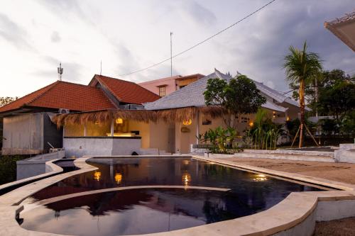 a swimming pool in front of a house at The Manik Toya in Uluwatu
