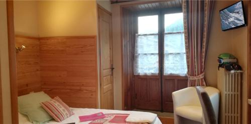 a bedroom with a bed and a window and a chair at Le Dôme in Tignes