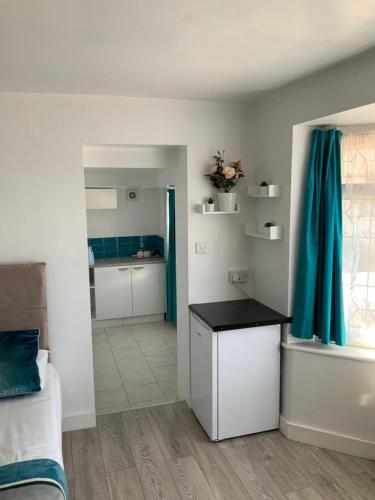 a room with a bed and a kitchen with a table at Stanwell Stansted Airport in Takeley