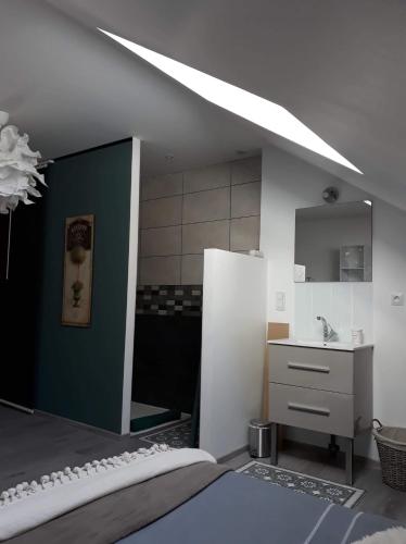 Cette chambre comprend un lit, un lavabo et un miroir. dans l'établissement La CASITA, à Bléré