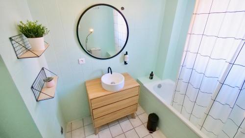a bathroom with a mirror and a sink and a tub at Bonheur in Schiltigheim