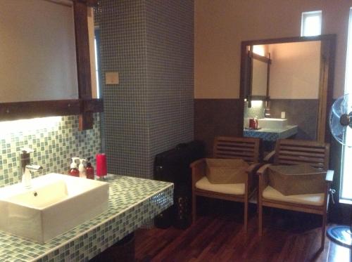 a bathroom with a sink and a mirror at Kunugi Relaxation with 4 modern rooms in Hakuba