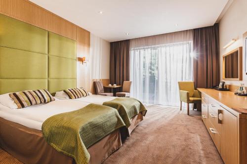 una habitación de hotel con una cama grande y una mesa en Hotel Kozi Gród, en Pomlewo