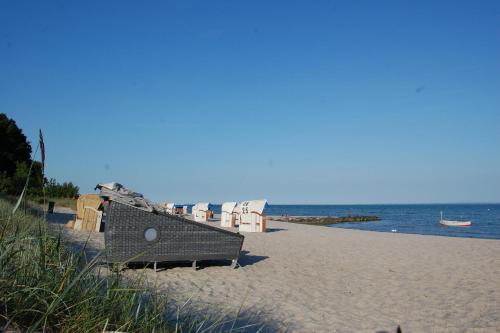 plaża z leżakami i ławką na plaży w obiekcie Schlafstrandkorb Nr. 1 w mieście Sierksdorf
