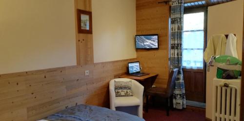 a bedroom with a bed and a desk with a computer at Le Dôme in Tignes