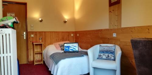 a bedroom with a bed and a chair with a laptop on it at Le Dôme in Tignes