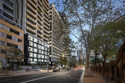 a city street with tall buildings and a road with cars at Quest North Sydney in Sydney