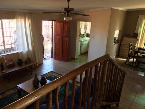 a room with a staircase and a living room with a door at Forget-Me-Not Cottage in Krugersdorp