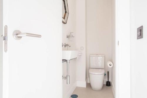 a white toilet sitting next to a white sink at Apartamentos RG Dúplex San Bernardo in Seville
