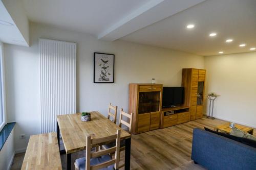 a living room with a dining table and a television at Ferienwohnung Essen - Zentral im Ruhrgebiet in Essen