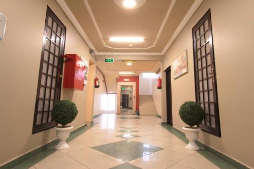 a hallway with two plants in a building at شقق منازل القصواء للشقق المخدومة إقتصادي in Buraydah